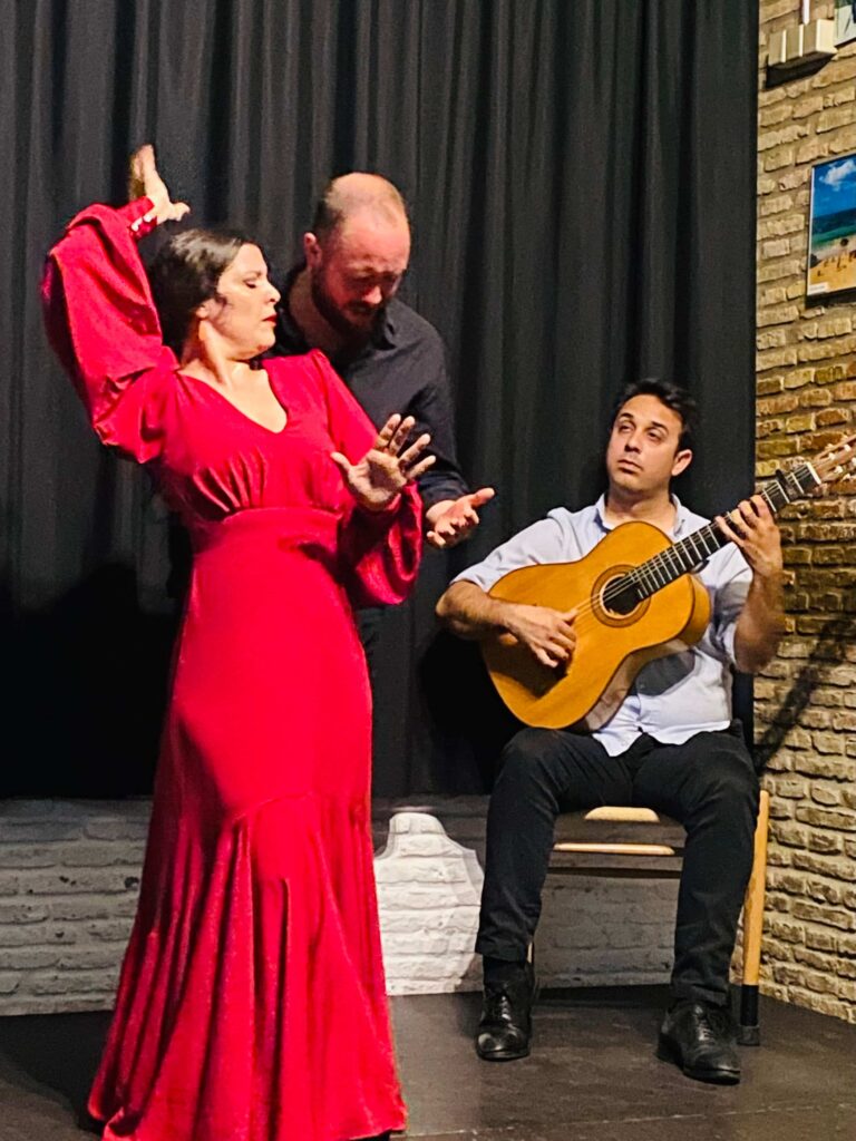 ballerina di flamenco vestita di rosso e alle sue spalle un chitarrista