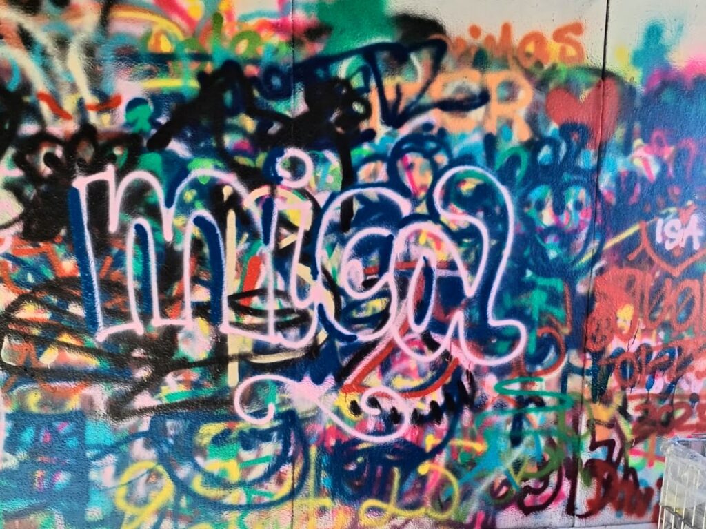 foto di un graffito rosa con la scritta Mica